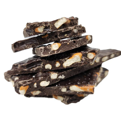 Stack of dark chocolate bark pieces with visible peanut butter pretzel chunks on a white background